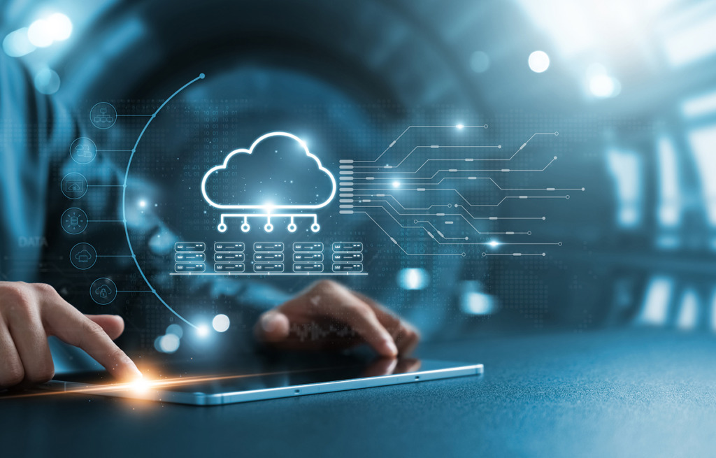 Person's hands using a tablet displaying a bright glowing cloud computing hologram and server icons.